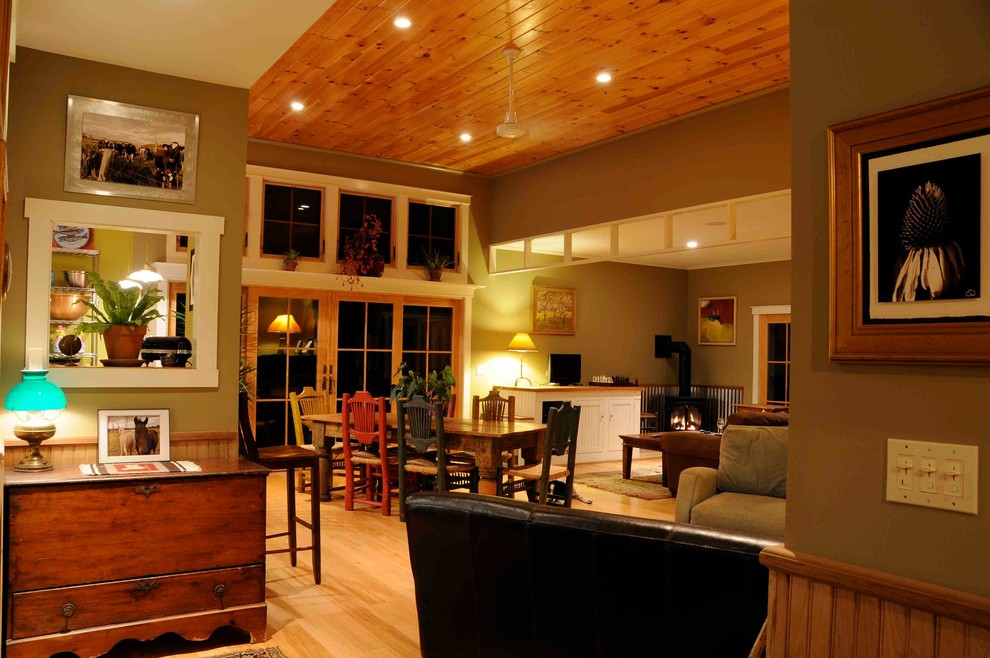 Источник вдохновения для домашнего уюта: открытая гостиная комната в стиле фьюжн с светлым паркетным полом, подвесным камином и желтыми стенами