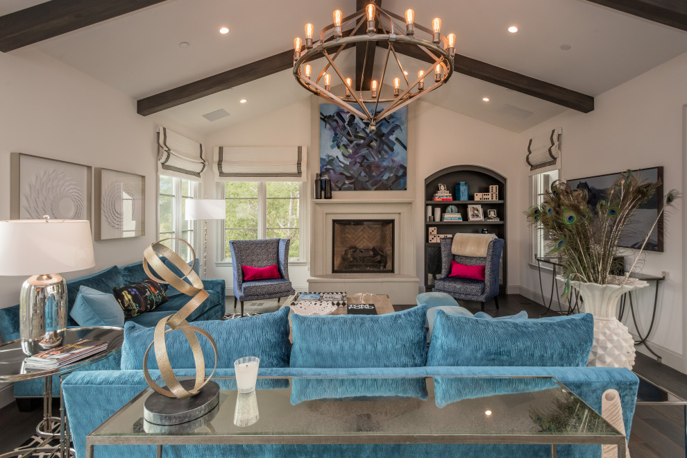 Large mediterranean grey and teal living room in San Francisco with white walls, dark hardwood flooring, a standard fireplace, brown floors, a vaulted ceiling and a plastered fireplace surround.