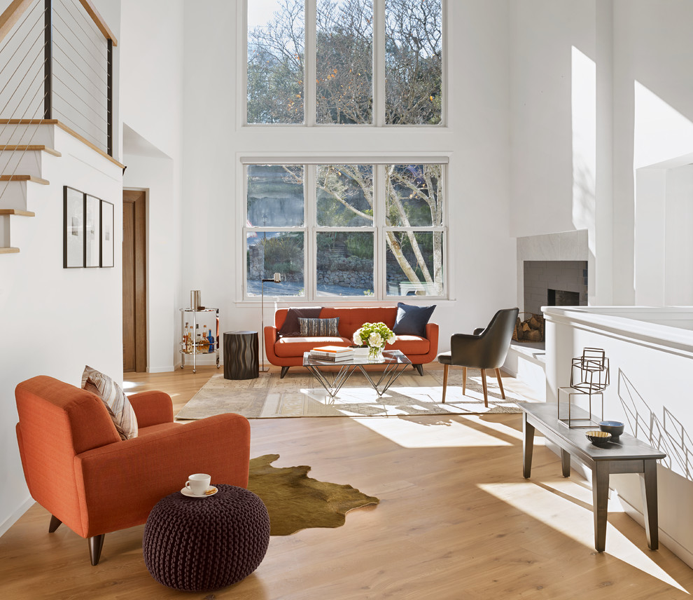Cette photo montre un salon scandinave de taille moyenne et ouvert avec un mur blanc, une cheminée standard, un manteau de cheminée en pierre, une salle de réception, un sol en bois brun et un sol marron.