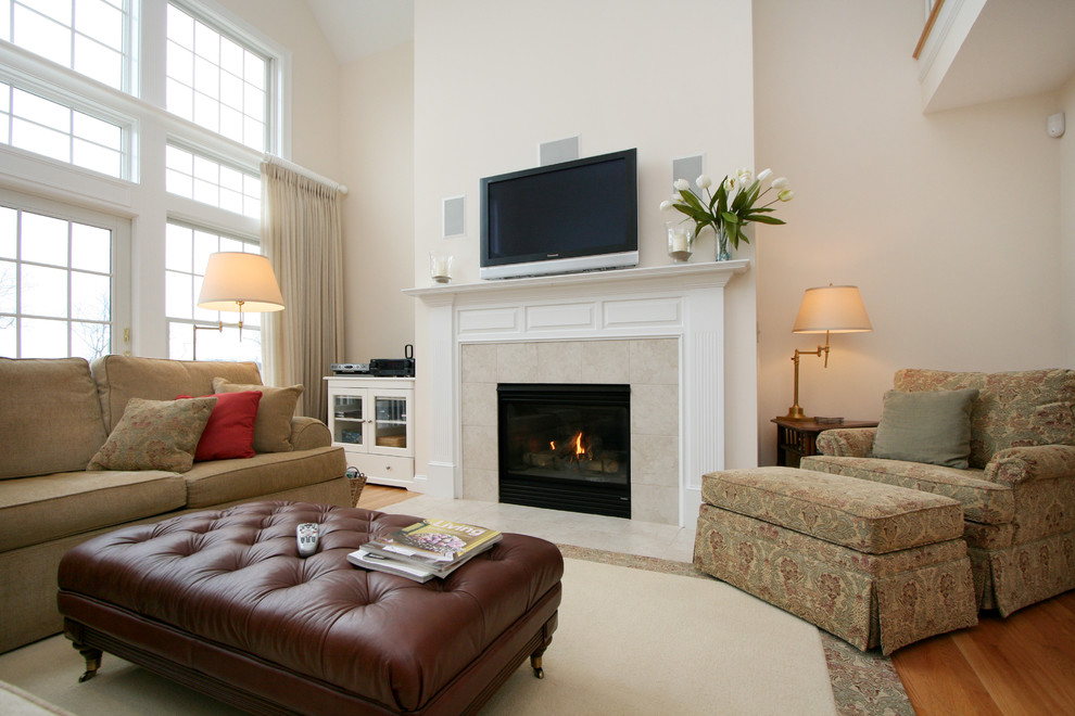 На фото: открытая гостиная комната в классическом стиле с светлым паркетным полом, стандартным камином, фасадом камина из камня и телевизором на стене с