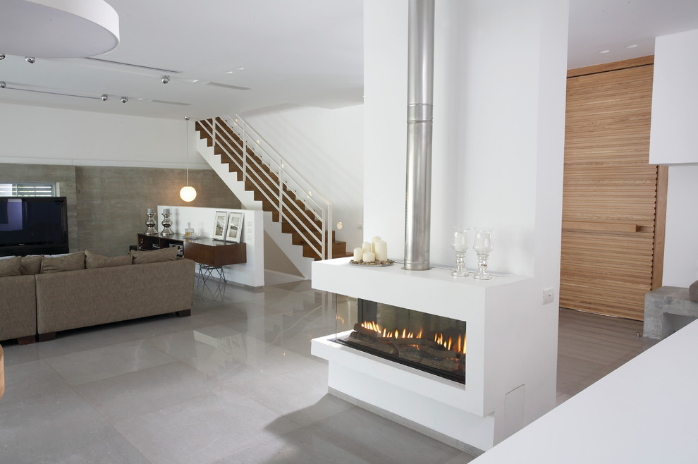 Modern open plan living room in San Francisco with white walls, grey floors and a ribbon fireplace.