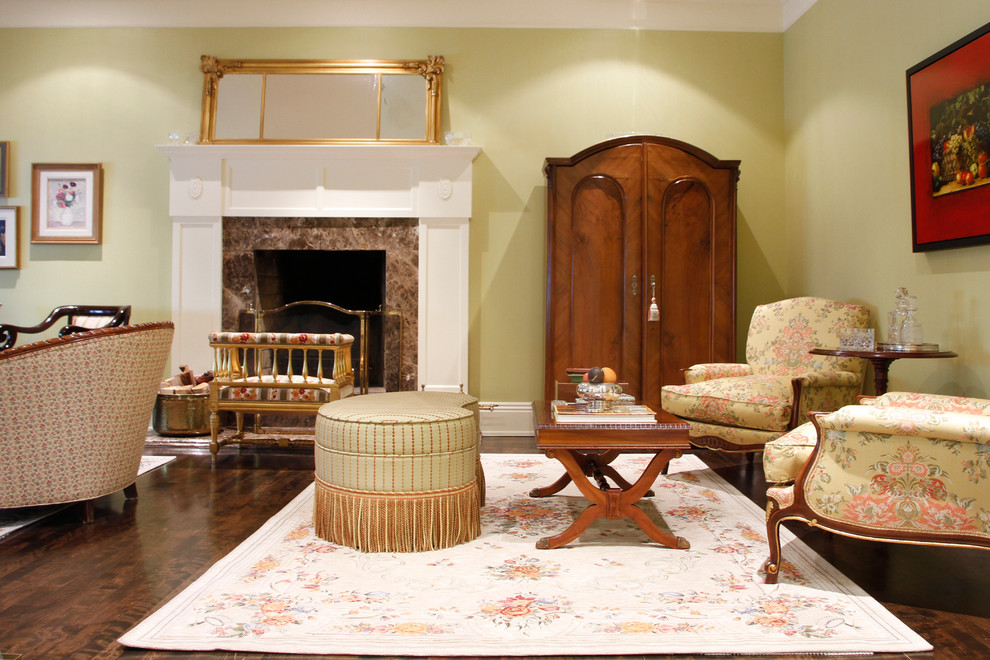 На фото: гостиная комната в классическом стиле с зелеными стенами, темным паркетным полом и стандартным камином с