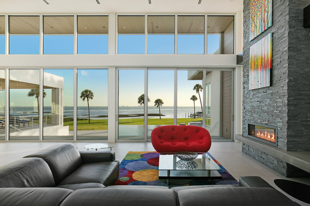 Living room - large modern open concept porcelain tile and gray floor living room idea in Tampa with white walls, a ribbon fireplace, a stone fireplace and a wall-mounted tv