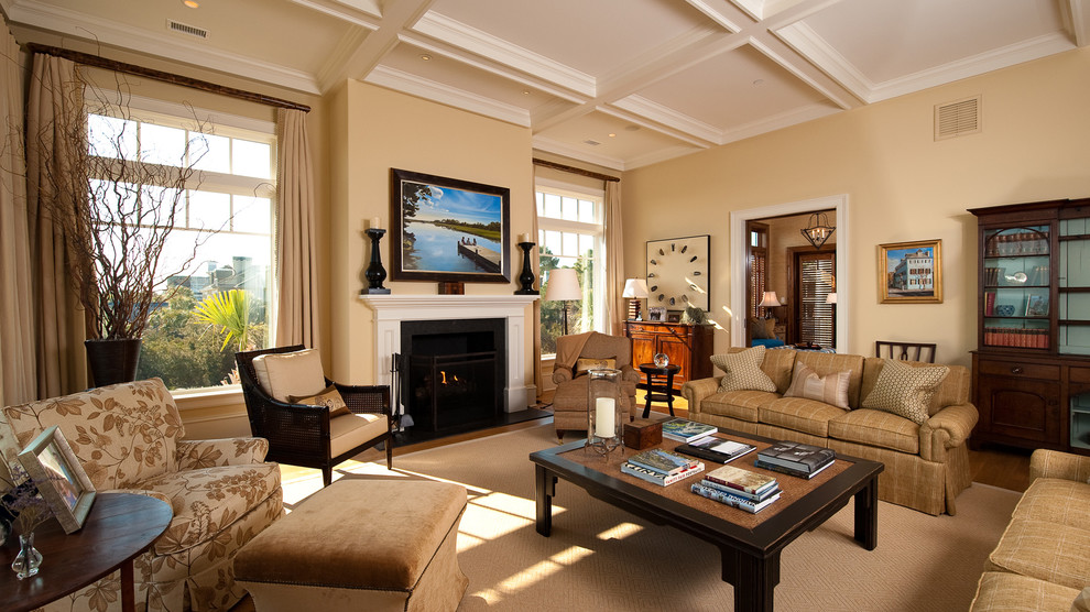 Photo of a large classic enclosed living room curtain in Charleston with a standard fireplace, no tv, yellow walls, medium hardwood flooring and a wooden fireplace surround.