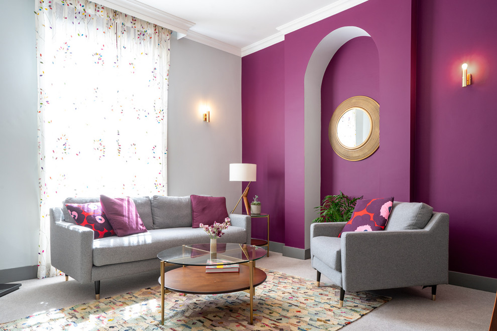 На фото: гостиная комната в стиле фьюжн с фиолетовыми стенами, ковровым покрытием и серым полом с