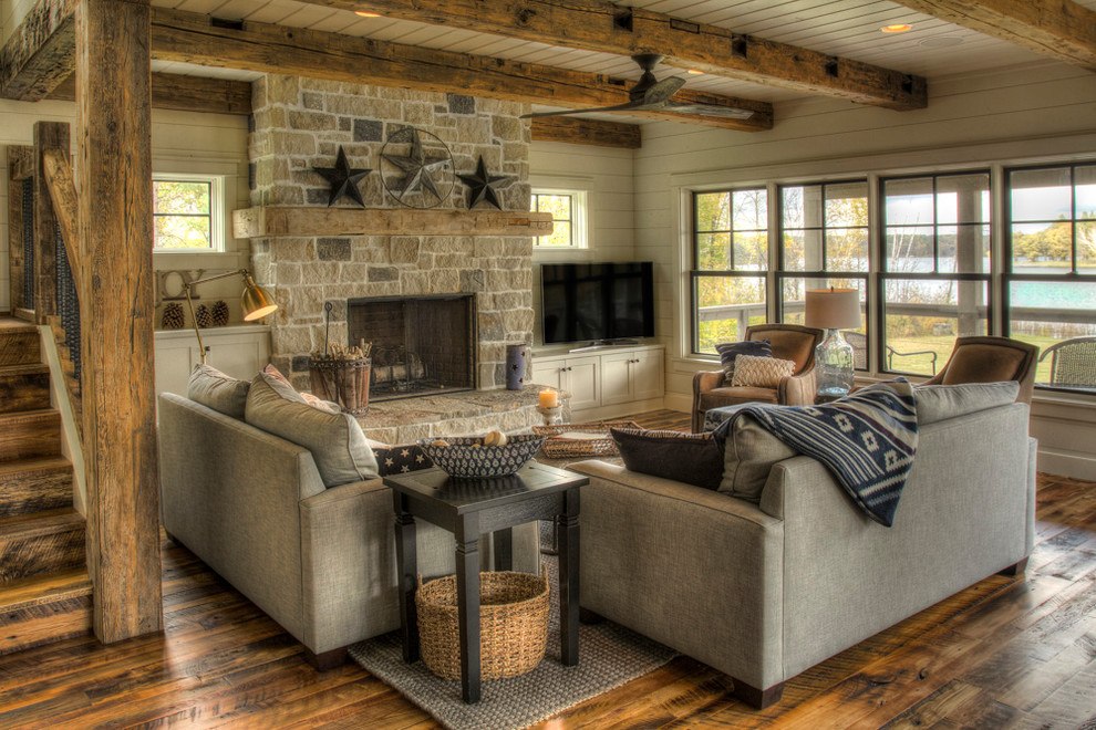Example of a mountain style open concept medium tone wood floor and brown floor living room design in Minneapolis with white walls, a standard fireplace, a stone fireplace and a tv stand