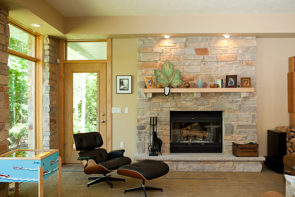 他の地域にあるコンテンポラリースタイルのおしゃれなリビング (ベージュの壁、標準型暖炉、石材の暖炉まわり) の写真