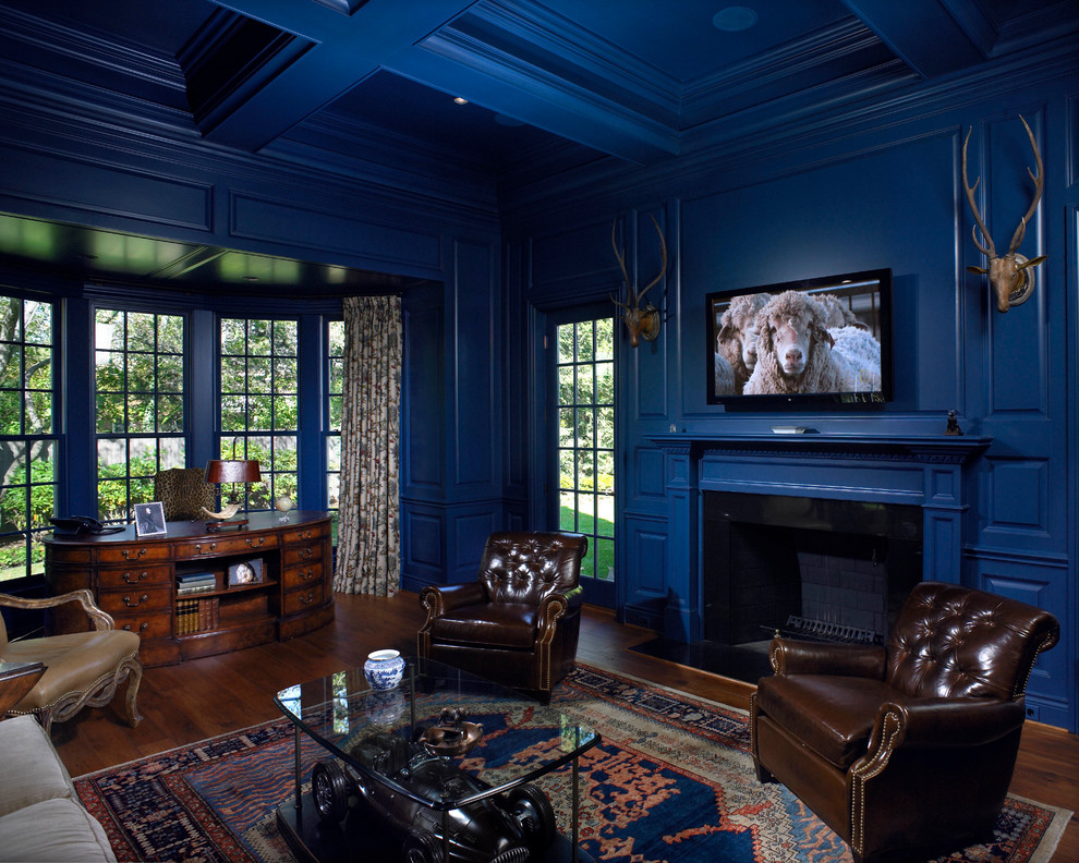 Elegant living room photo in Detroit with blue walls, a standard fireplace, a wood fireplace surround and a wall-mounted tv