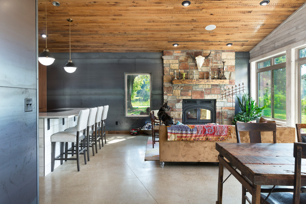Cette image montre un salon sud-ouest américain ouvert avec un mur gris, sol en béton ciré, une cheminée standard et un sol gris.
