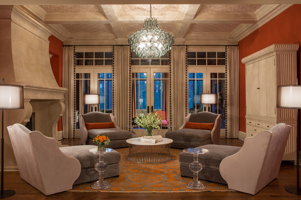 На фото: большая открытая гостиная комната в стиле неоклассика (современная классика) с оранжевыми стенами, паркетным полом среднего тона, стандартным камином, фасадом камина из камня и скрытым телевизором с