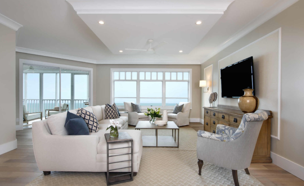 Inspiration for a large beach style open plan living room in Miami with beige walls, medium hardwood flooring, no fireplace, a wall mounted tv and brown floors.