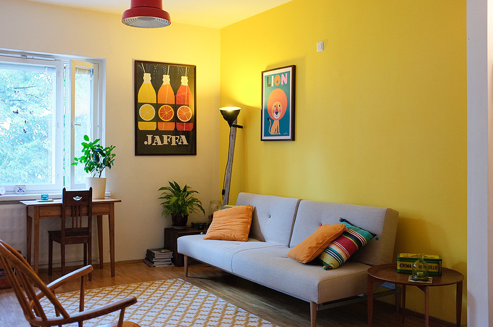 Свежая идея для дизайна: гостиная комната в стиле фьюжн с желтыми стенами и паркетным полом среднего тона - отличное фото интерьера