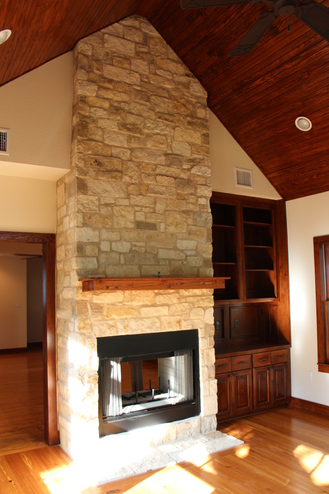 Modelo de salón abierto clásico renovado grande con paredes beige, suelo de madera en tonos medios, todas las chimeneas, marco de chimenea de piedra y suelo marrón