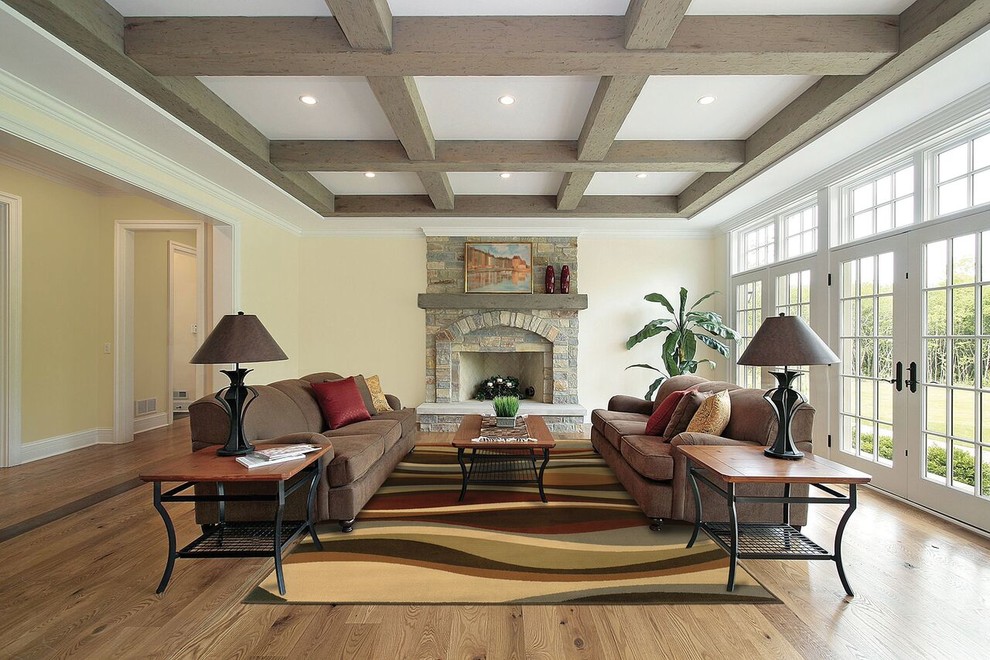 Diseño de salón abierto clásico renovado de tamaño medio con paredes beige, suelo de madera en tonos medios, todas las chimeneas y marco de chimenea de piedra