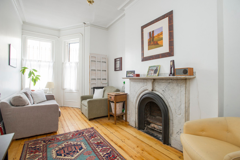Repräsentatives, Fernseherloses, Kleines Klassisches Wohnzimmer ohne Kamin, im Loft-Stil mit weißer Wandfarbe, hellem Holzboden, Kaminumrandung aus Stein und beigem Boden in Boston