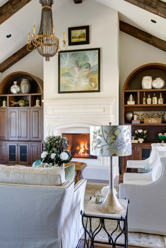 Photo of a large farmhouse open plan living room in Nashville with beige walls, medium hardwood flooring, a standard fireplace, a plastered fireplace surround and brown floors.