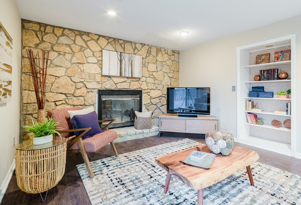Abgetrenntes Eklektisches Wohnzimmer mit beiger Wandfarbe, Laminat, Kamin, Kaminumrandung aus Stein, Eck-TV und braunem Boden in Cincinnati