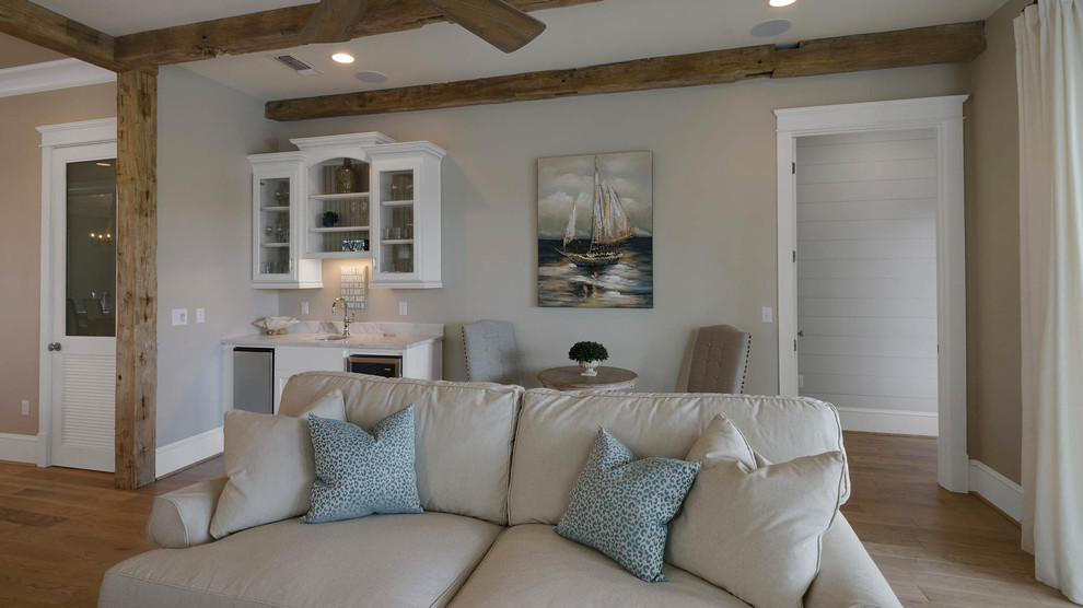 Foto de salón para visitas abierto marinero de tamaño medio sin chimenea con paredes beige, suelo de madera clara y televisor colgado en la pared