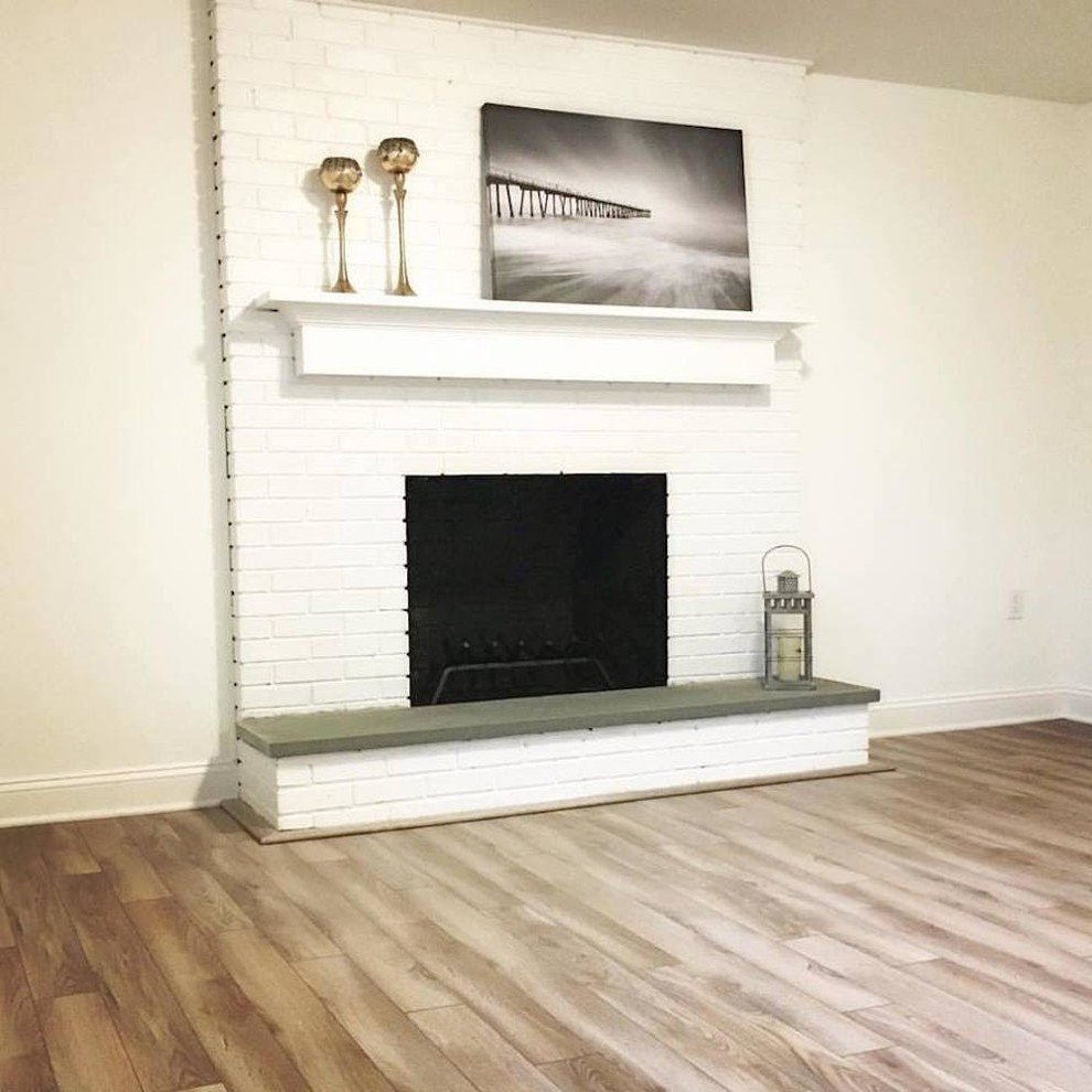 Medium sized classic formal open plan living room in Bridgeport with white walls, medium hardwood flooring, a standard fireplace, a brick fireplace surround, no tv and brown floors.