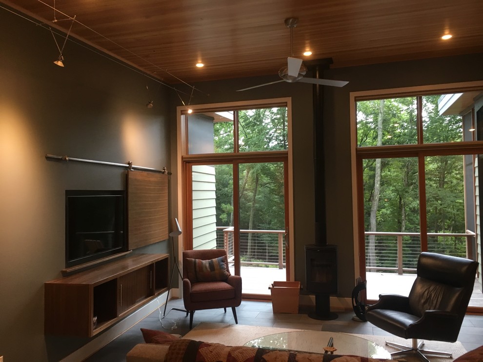 На фото: открытая гостиная комната среднего размера в стиле неоклассика (современная классика) с зелеными стенами, полом из сланца и телевизором на стене без камина с