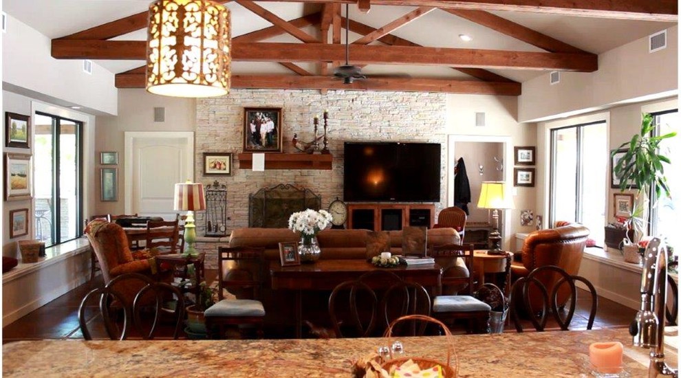 Foto de salón para visitas cerrado de estilo americano de tamaño medio con paredes beige, suelo de pizarra, todas las chimeneas, marco de chimenea de piedra y televisor colgado en la pared