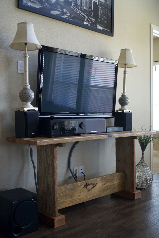 Imagen de salón cerrado rural de tamaño medio con paredes beige, suelo de madera oscura, televisor independiente, todas las chimeneas, marco de chimenea de piedra y suelo marrón