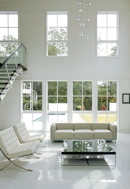 На фото: большая двухуровневая гостиная комната в стиле модернизм с белыми стенами, полом из керамогранита, горизонтальным камином и фасадом камина из штукатурки с
