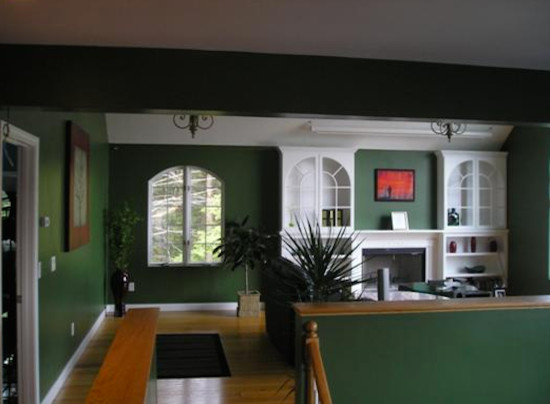 Пример оригинального дизайна: открытая гостиная комната среднего размера с зелеными стенами, паркетным полом среднего тона, стандартным камином и фасадом камина из дерева