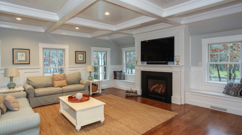 Immagine di un ampio soggiorno stile americano aperto con pareti grigie, pavimento in legno massello medio e parete attrezzata