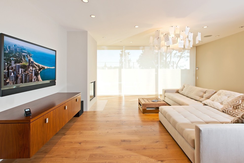 Trendy living room photo in Los Angeles with beige walls, a standard fireplace and a wall-mounted tv
