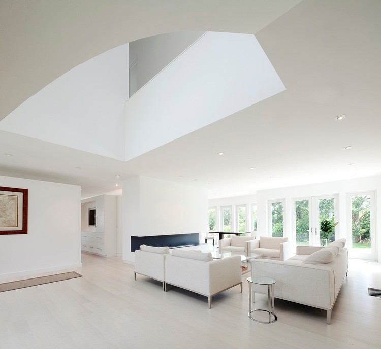 Стильный дизайн: большая парадная, открытая гостиная комната в стиле модернизм с белыми стенами, светлым паркетным полом и горизонтальным камином - последний тренд