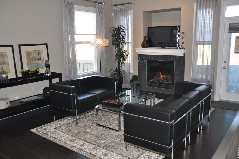 Design ideas for a medium sized contemporary formal enclosed living room in Calgary with a standard fireplace, a tiled fireplace surround, beige walls, porcelain flooring, a freestanding tv and grey floors.