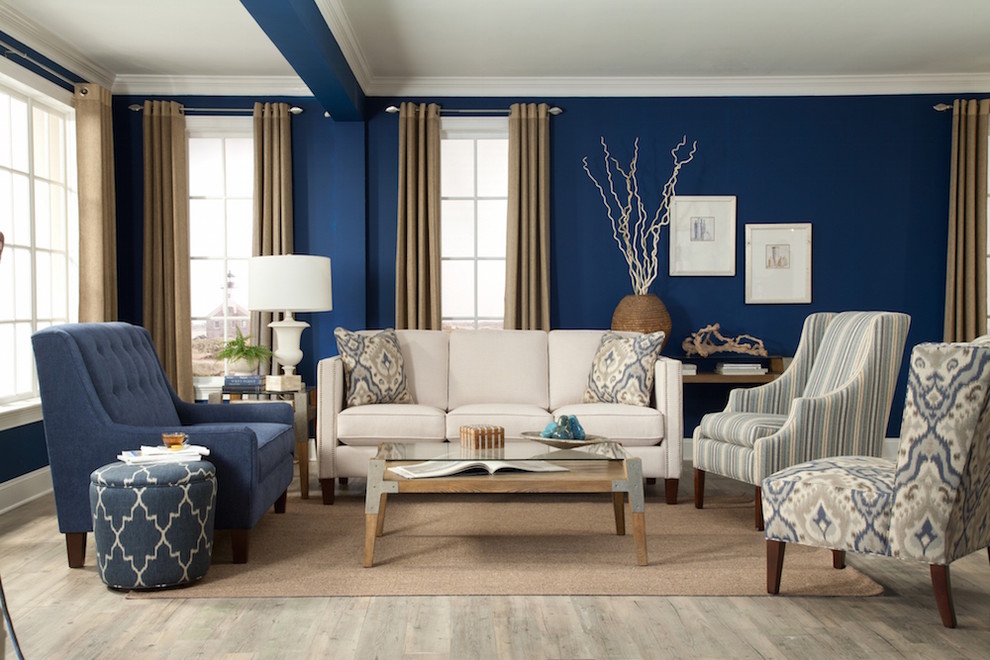 Foto på ett vardagsrum, med blå väggar och ljust trägolv