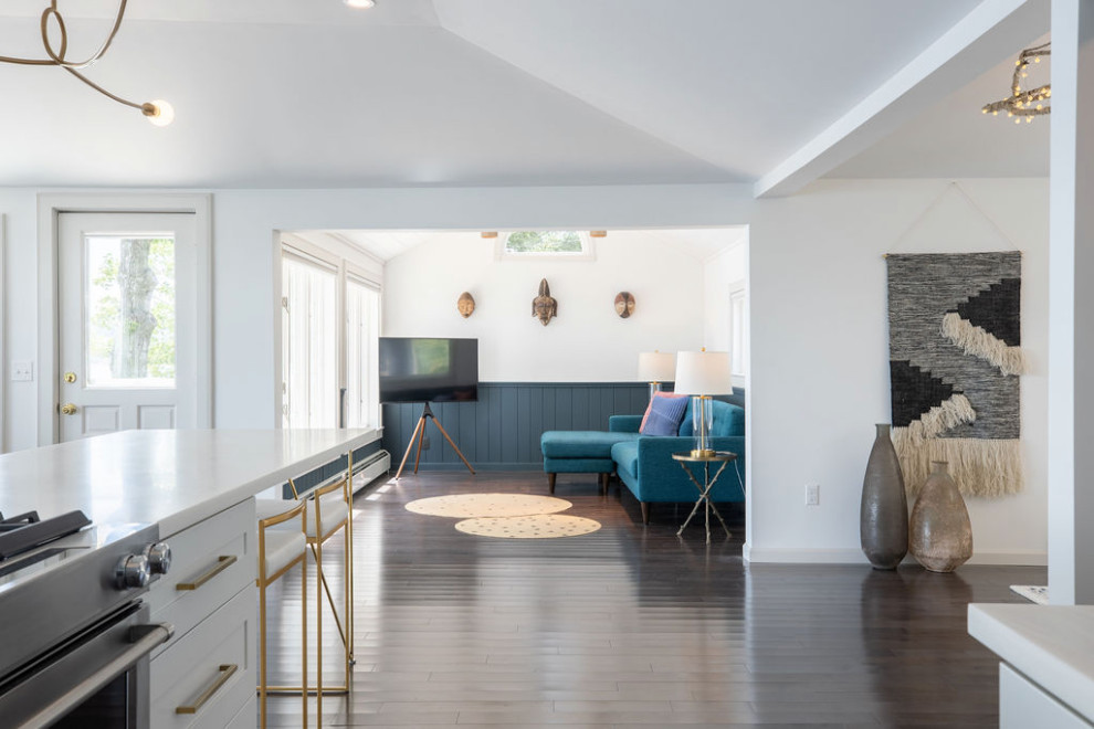 Mittelgroßes, Offenes Modernes Wohnzimmer mit blauer Wandfarbe, dunklem Holzboden, Eck-TV, gewölbter Decke und Wandpaneelen in Portland Maine