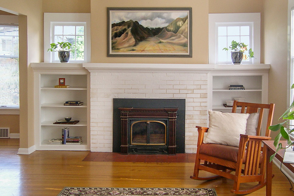 Exemple d'un petit salon chic avec un mur beige, parquet clair, une cheminée standard, un manteau de cheminée en brique et un sol marron.