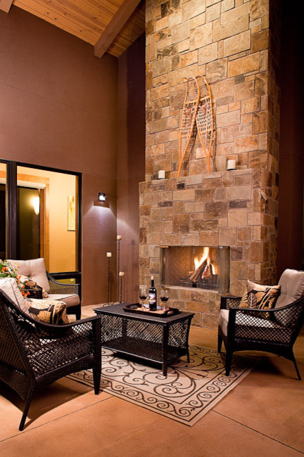 Photo of a small contemporary mezzanine living room in Denver with brown walls, concrete flooring, a standard fireplace, a stone fireplace surround and no tv.