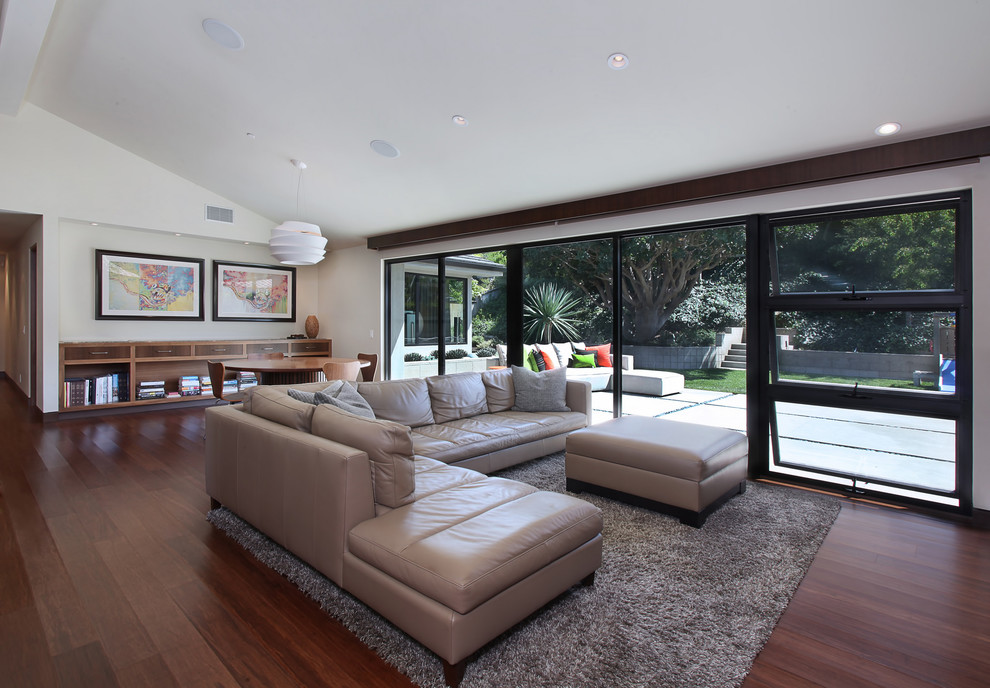 Esempio di un soggiorno minimalista aperto con pavimento in bambù e pareti bianche