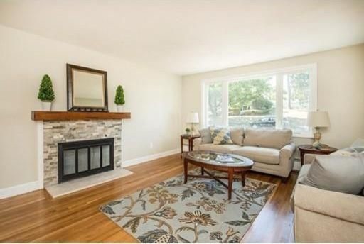 Example of a large classic formal and enclosed medium tone wood floor and beige floor living room design in Boston with white walls, a standard fireplace, a tile fireplace and no tv