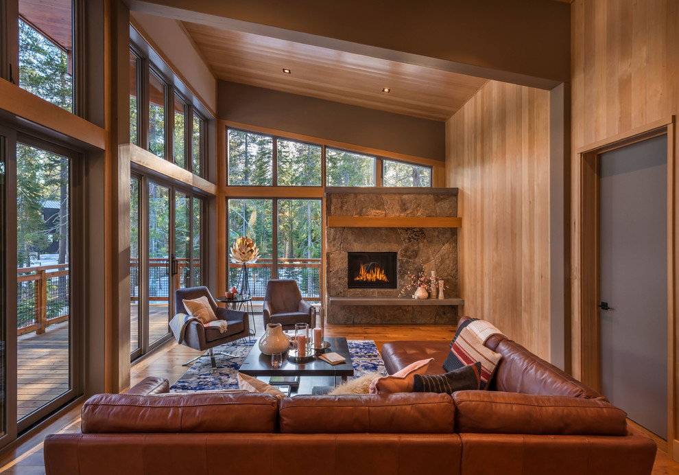 ラスティックスタイルのおしゃれなリビング (茶色い壁、無垢フローリング、標準型暖炉、石材の暖炉まわり、茶色い床) の写真