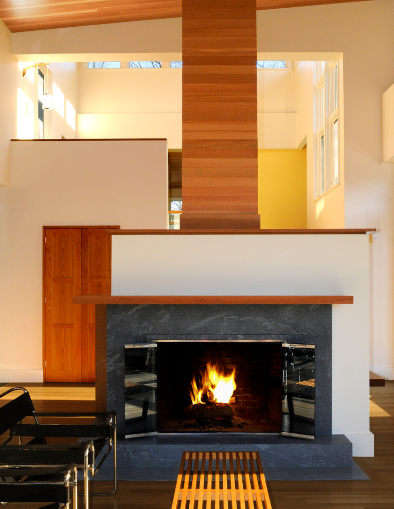 Photo of a contemporary living room in Boston with beige walls, a standard fireplace and a stone fireplace surround.