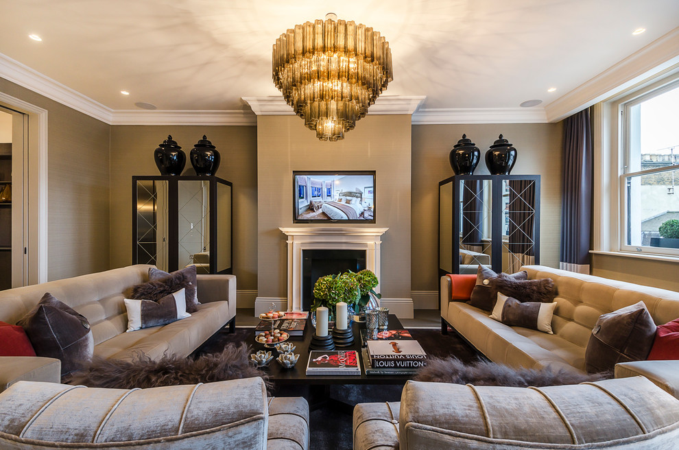 This is an example of a traditional formal living room in London with beige walls, dark hardwood flooring, a standard fireplace and a wall mounted tv.