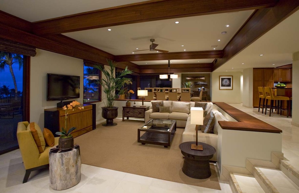 Bild på ett tropiskt vardagsrum, med beige väggar och en fristående TV
