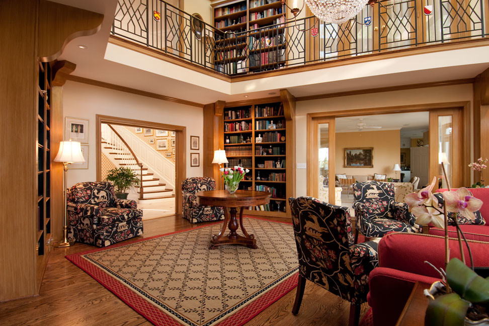 Imagen de biblioteca en casa tradicional extra grande con suelo de madera en tonos medios