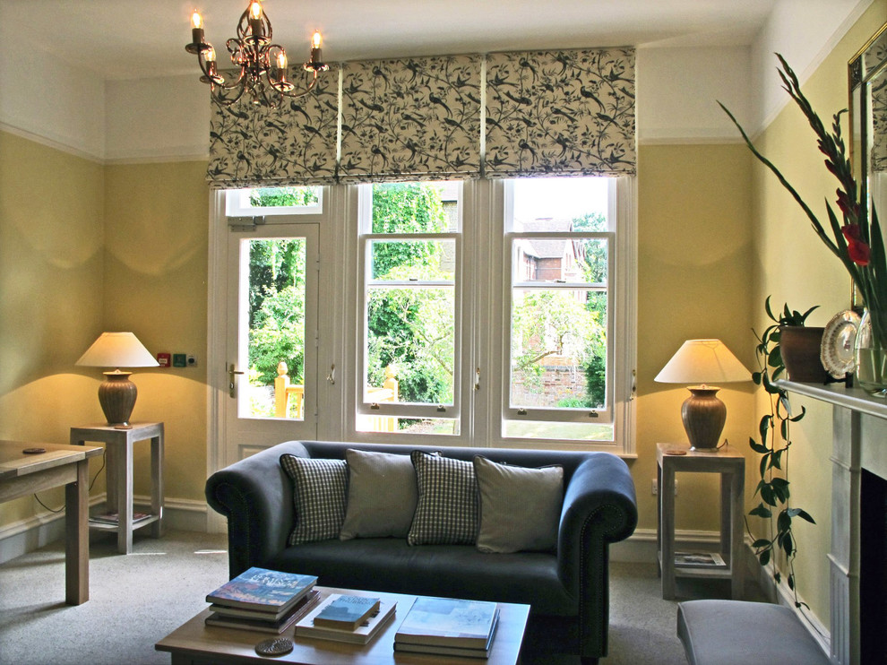 Example of a mid-sized trendy formal and enclosed carpeted living room design in Oxfordshire with yellow walls, a standard fireplace, a stone fireplace and a wall-mounted tv
