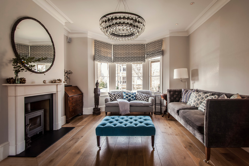 Mittelgroßes, Repräsentatives, Fernseherloses Klassisches Wohnzimmer mit grauer Wandfarbe, braunem Holzboden und Kaminofen in Hampshire