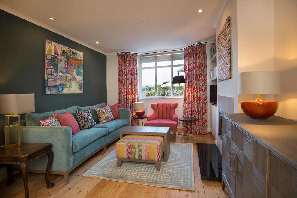 This is an example of a medium sized eclectic living room in Oxfordshire with blue walls, painted wood flooring, a freestanding tv, brown floors, a wallpapered ceiling and wallpapered walls.