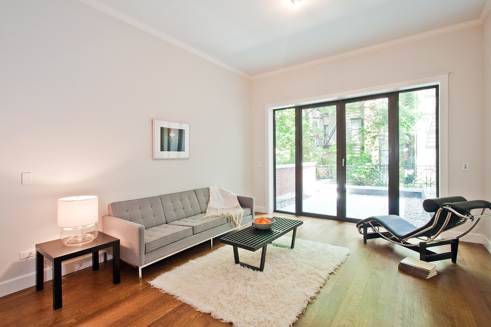 Fernseherloses, Abgetrenntes Klassisches Wohnzimmer ohne Kamin mit weißer Wandfarbe und braunem Holzboden in New York