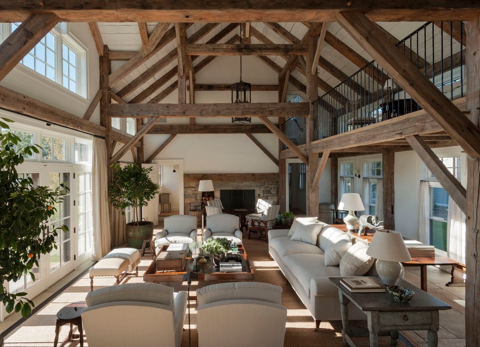 Foto de salón abierto de estilo de casa de campo extra grande con paredes beige, todas las chimeneas y marco de chimenea de piedra