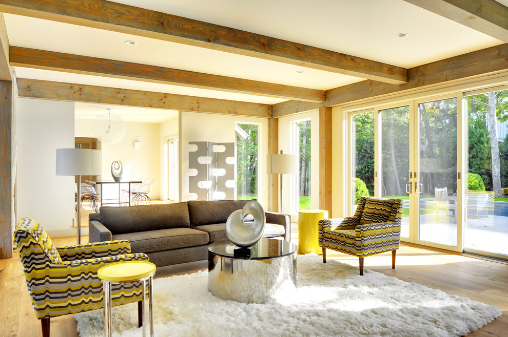 Exemple d'un grand salon tendance ouvert avec un mur gris, parquet clair, une cheminée double-face et un manteau de cheminée en béton.
