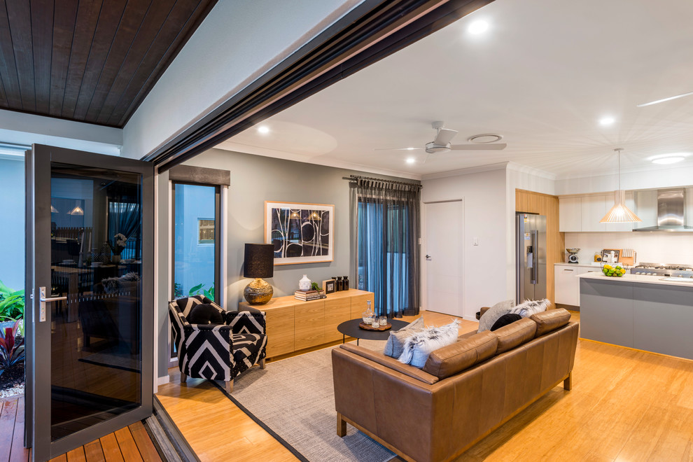На фото: открытая гостиная комната среднего размера в современном стиле с серыми стенами и полом из бамбука с